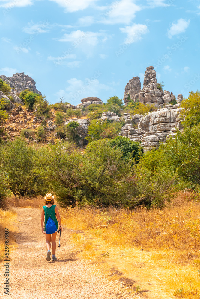 A young woman trekking in the Torcal de Antequera on the green and yellow trail, Malaga. Spain