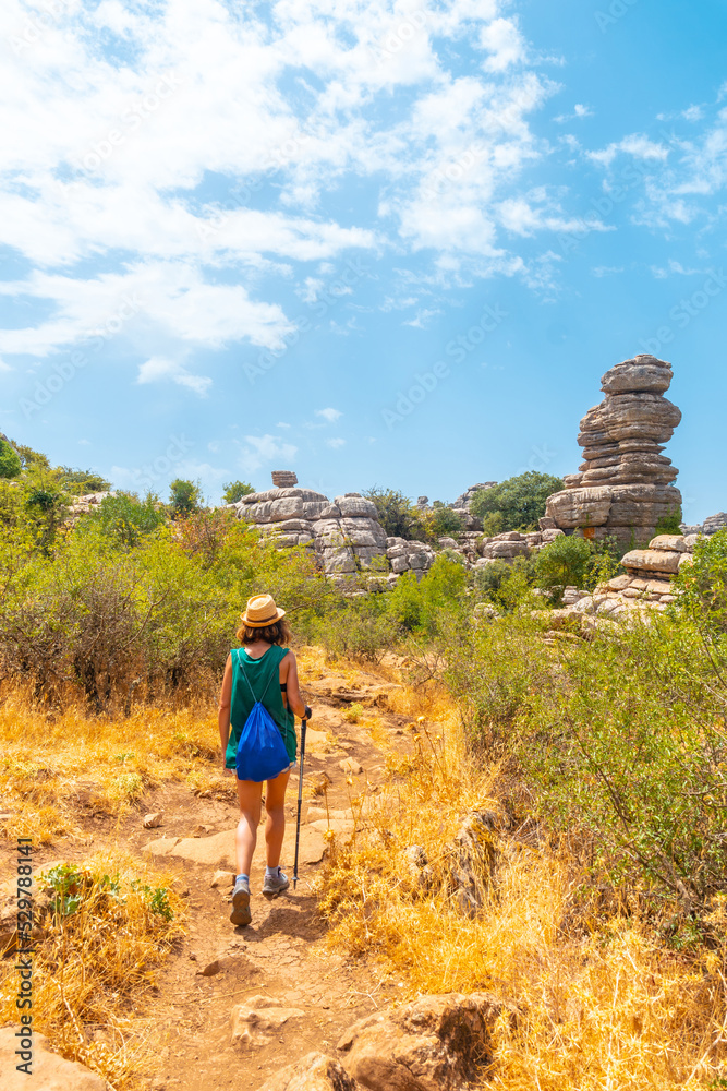 A young woman trekking in Torcal de Antequera on the green and yellow trail, Malaga