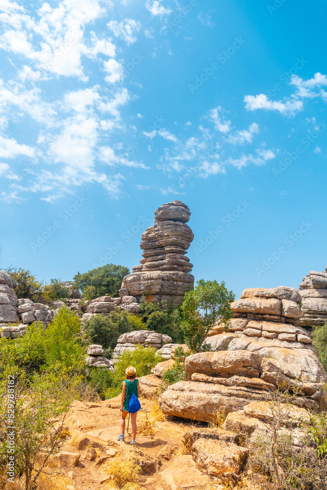 A young woman trekking in the Torcal de Antequera on the green and yellow trail enjoying the summer, Malaga