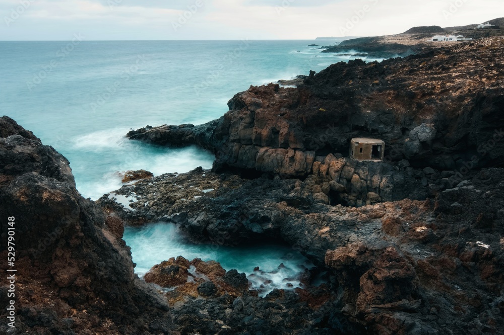 Beautiful coastal seascape scenery with fisherman's shelter and cave at Charco del Palo, Lanzerote, Canary Islands, Spain 