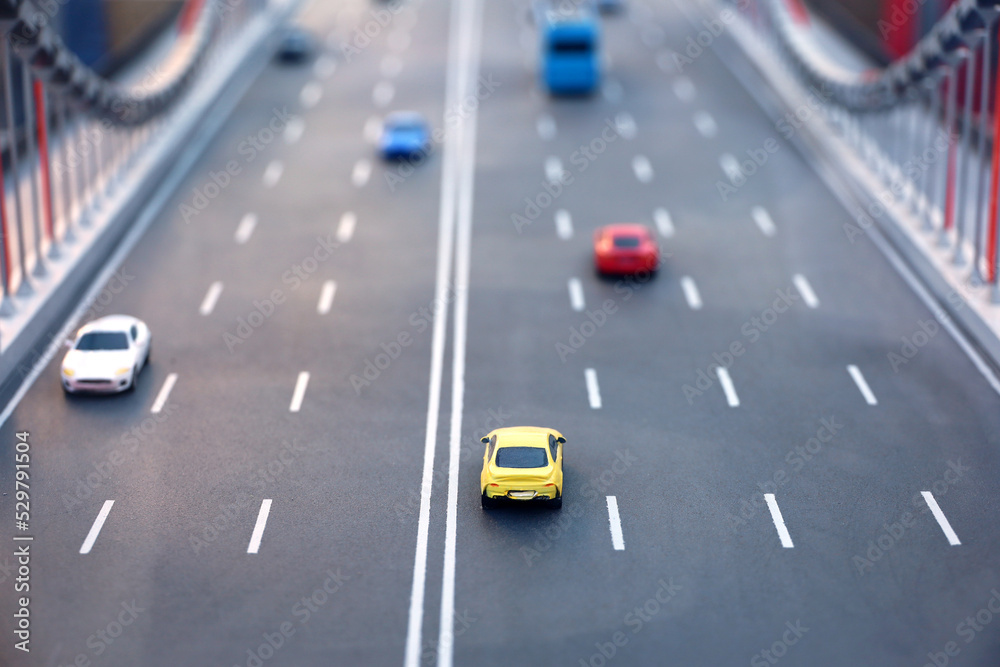 Toy cars and buses on multi lane highway, model of the bridge