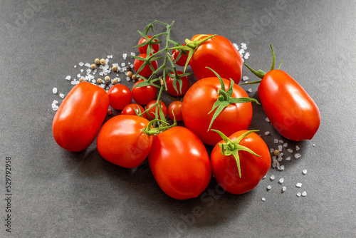 Frische, reife Tomaten in unterschiedlicher Größe und Form mit grobem Salz und Pfefferkörnern