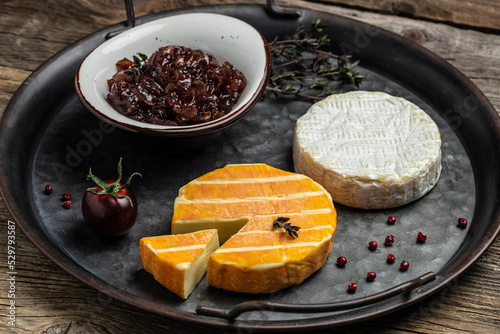 Camembert, Brie, Gorgonzola and blue cream cheese with thyme and onion marmalade jam. French cuisine. An aperitif on a gray background. place for text, top view