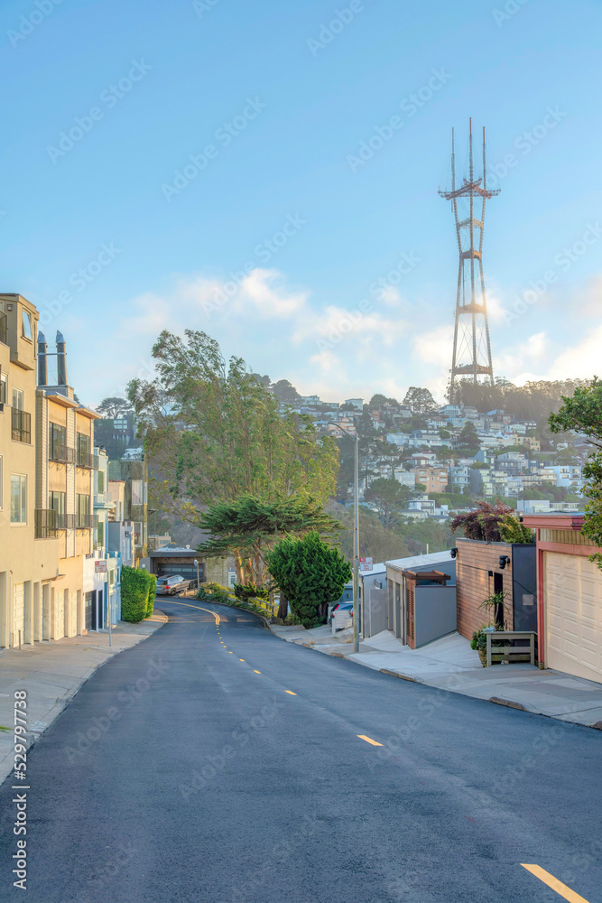 View of Sutro Tower from the road in the middle of residential buildings in San Francisco, CA