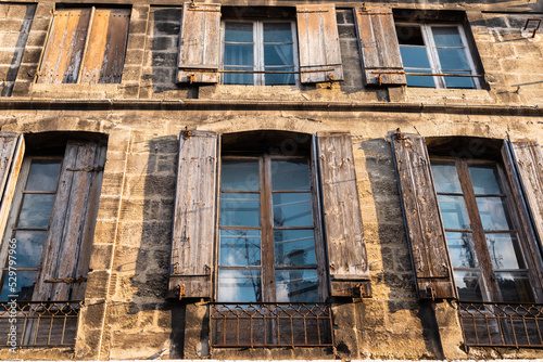 Windows with shutters in a neglected tenement house