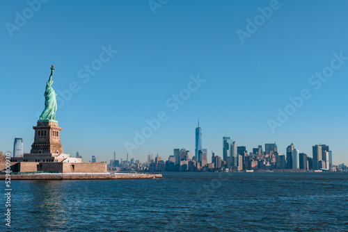 View of the skylines of Manhattan (New York City, USA), with the statue of liberty in the foreground.