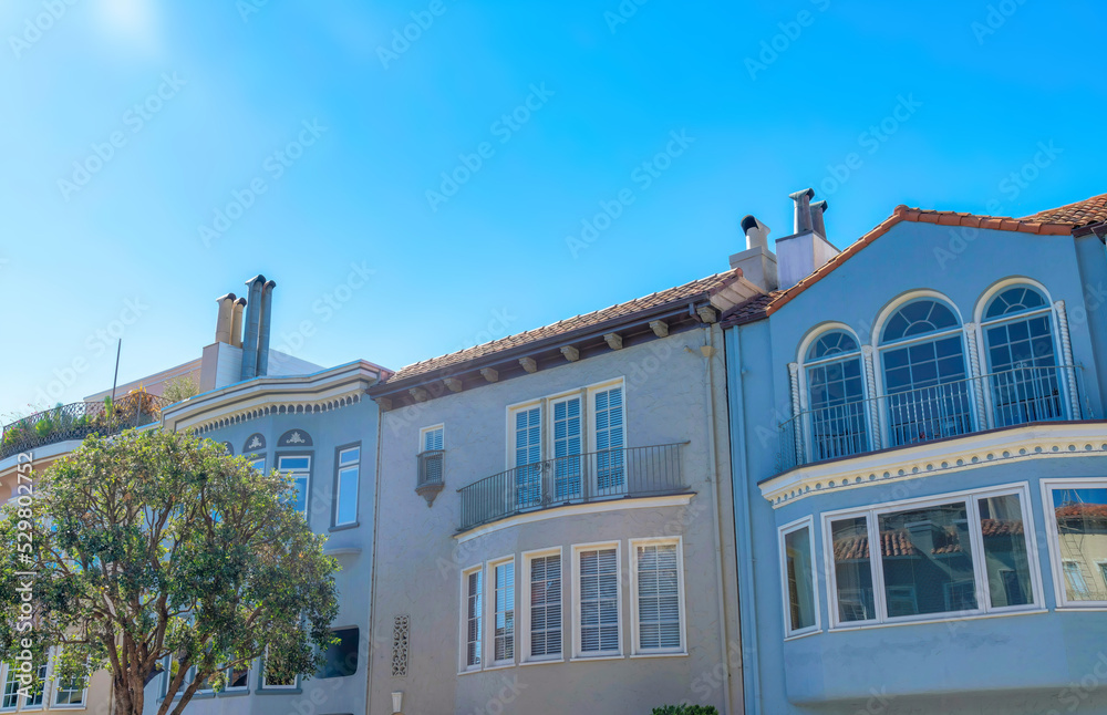 Adjacent houses with italiante design against the clear blue sky in San Francisco, California