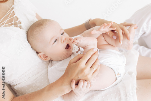 Mother sits and plays with her baby.