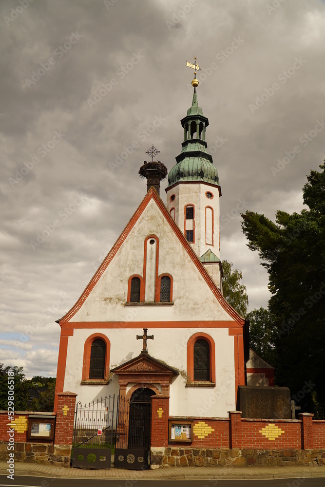 Protestant parish church with a large stork nest on the roof in Otterwisch near Leipzig, Germany. The church dates back to the 12th century and has been rebuilt several times. 