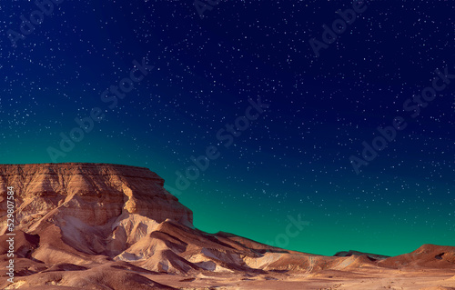 Mountains Sodom Gomorrah under starry night sky. Starry dark sky over the golden sand dunes in Judean desert, Israel. Soft focus. Night landscape with a large salt mountain, cliffs in Dead Sea.