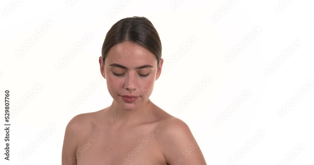 Portrait of a brunette woman applying deodorant under her armpits then looking into the camera. Isolated on a white background. Portrait of a brunette woman applying deodorant under her armpits then looking into the camera. Isolated on a white background.