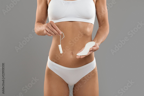 Intimate Hygiene. Young woman in underwear holding tampon and clean menstrual pad