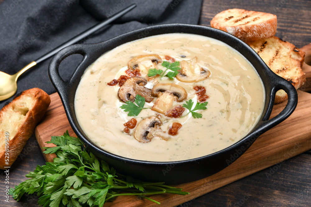 Mushroom champignon soup with bread and fresh mushrooms on a wooden background , autumn seasonal cream soup with vegetables
