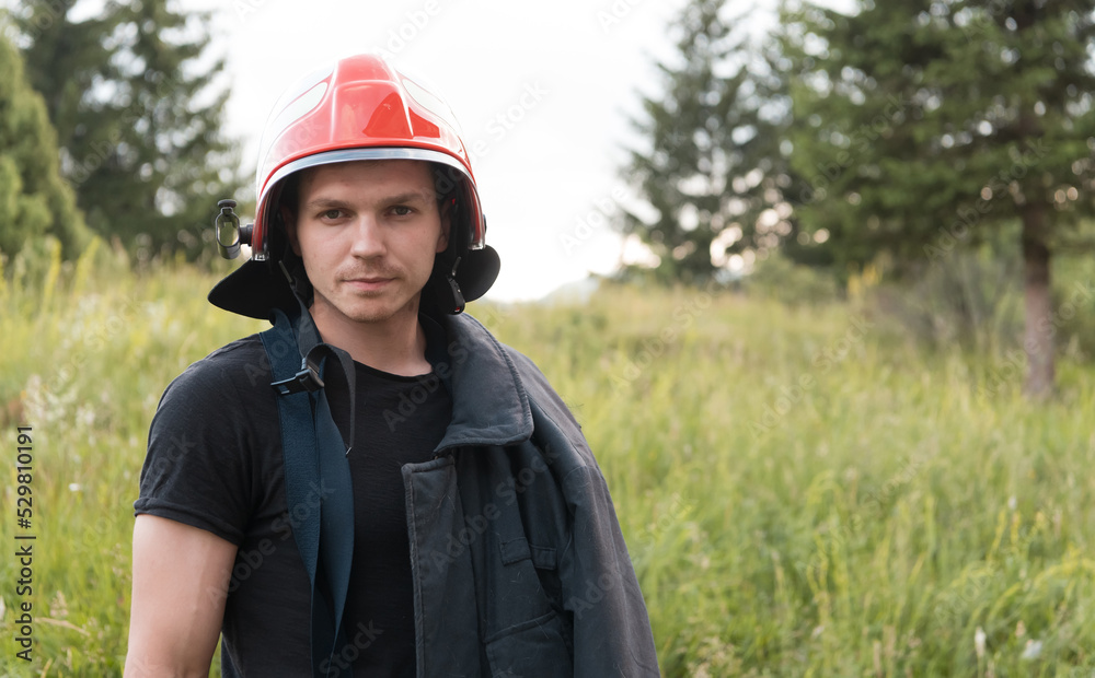 Firefighter with uniform and helmet stand in front of electric wire on a roof top Firefighter with uniform and helmet stand in front of electric wire on a roof top