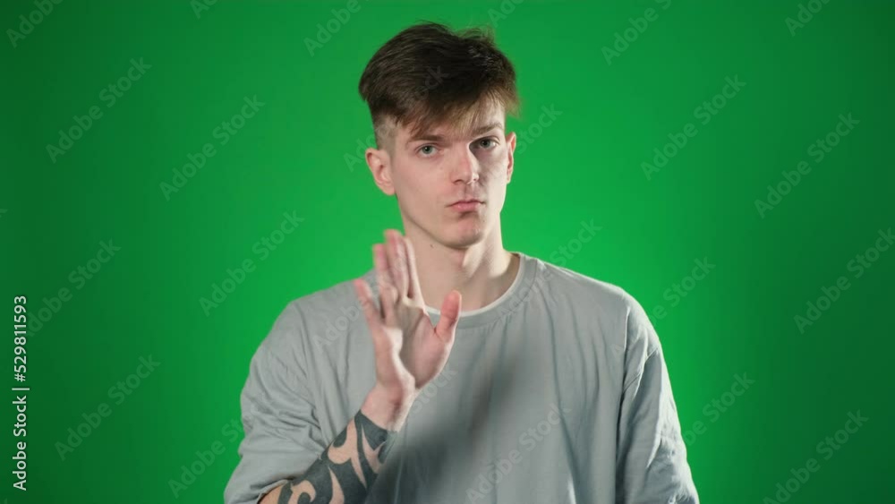 Handsome man holding finger on his lips over green background Handsome man holding finger on his lips over green background