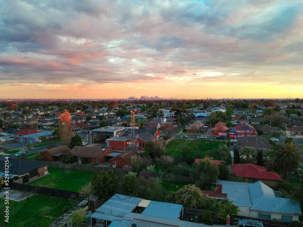 Panoramic aerial Drone view of Melbournes suburbs and CBD looking down at Houses roads and Parks Victoria Australia. Beautiful colours at Sunset