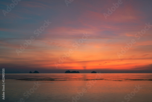 Colorful dramatic sky over the sea and islands. Reflections in the water.