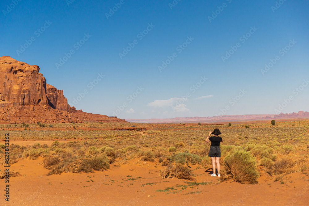 Tourist photographer woman taking pictures in Monument Valley, Arizona, USA