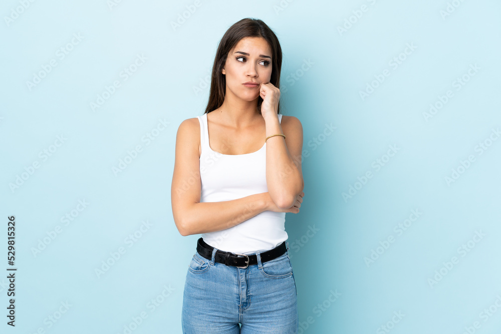 Young caucasian woman isolated on blue background with tired and bored expression Young caucasian woman isolated on blue background with tired and bored expression
