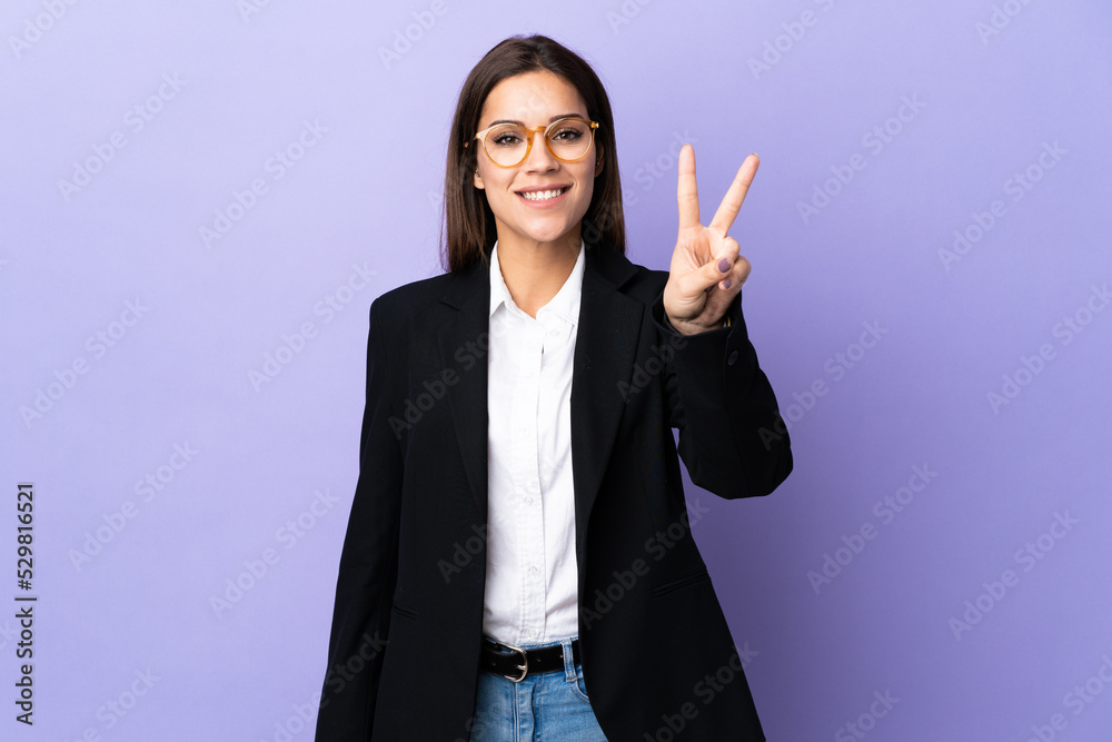 Business woman isolated on purple background smiling and showing victory sign Business woman isolated on purple background smiling and showing victory sign
