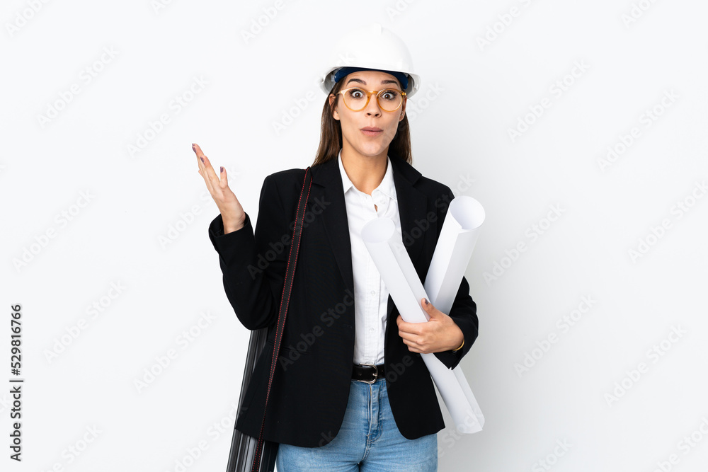 Young architect caucasian woman with helmet and holding blueprints over isolated background with surprise facial expression Young architect caucasian woman with helmet and holding blueprints over isolated background with surprise facial expression