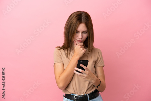 Young English woman isolated on pink background thinking and sending a message