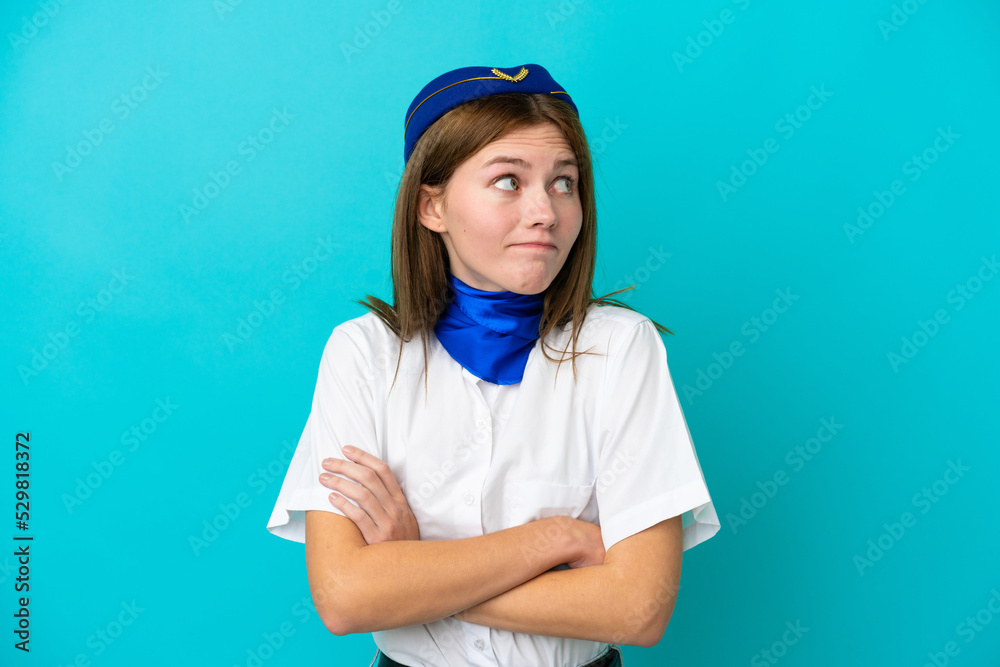 Airplane stewardess English woman isolated on blue background making doubts gesture while lifting the shoulders Airplane stewardess English woman isolated on blue background making doubts gesture while lifting the shoulders