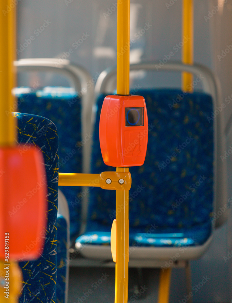 Bus handrails with validator. Payment acceptance validator. Equipment for payment by travel card. NFC payment acceptance system. Interior of modern bus. NFC fare validator. Selective blurred focus.