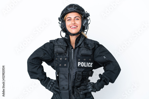 SWAT caucasian woman isolated on white background posing with arms at hip and smiling