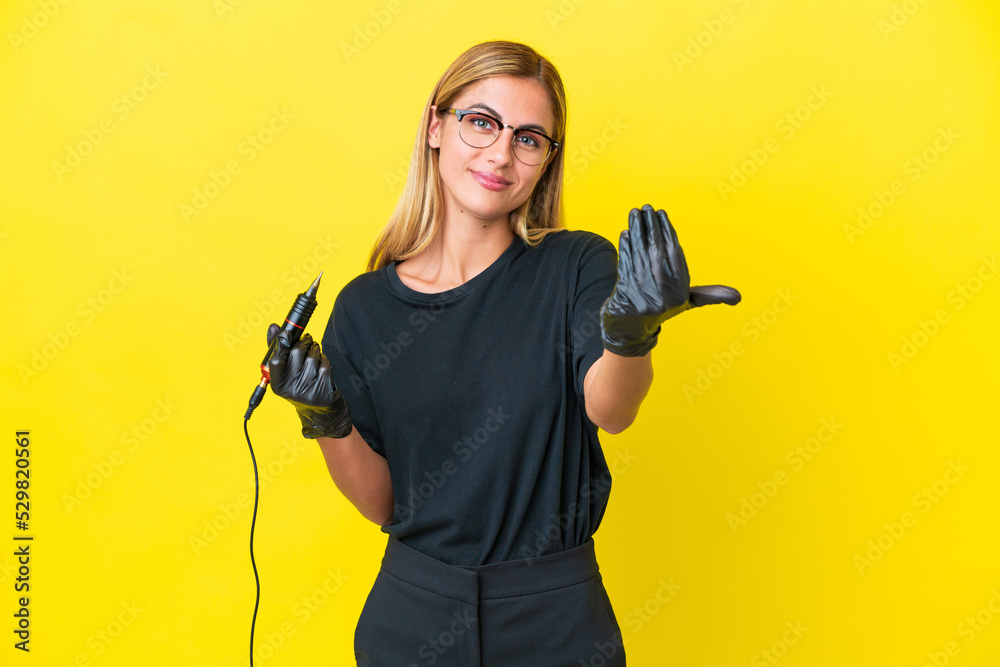 Tattoo artist Uruguayan woman isolated on yellow background inviting to come with hand. Happy that you came Tattoo artist Uruguayan woman isolated on yellow background inviting to come with hand. Happy that you came