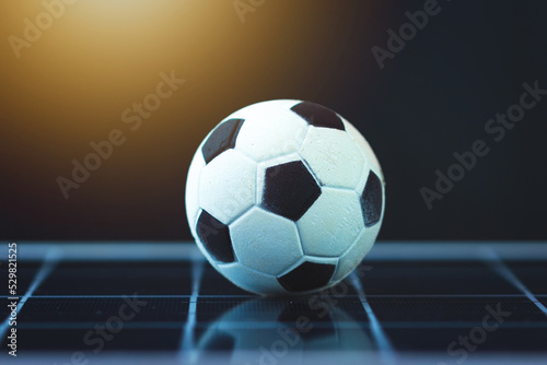 Soccer ball on photovoltaic solar panel isolated. Sport and technology concept image.