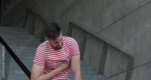 Man having heart attack on stairs, outdoors