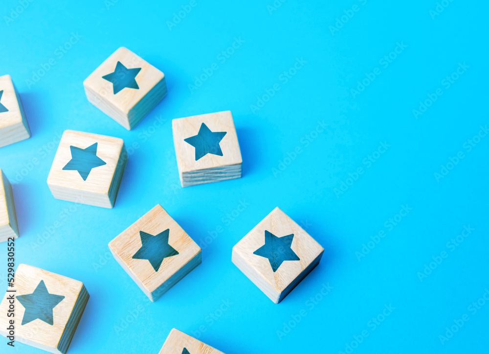 Obraz premium Scattered star blocks on a blue background. Popularity and fame. Feedback. Inspection, review. Benefits, positive things. New features. Ratings and reviews. Parties and celebrate events.