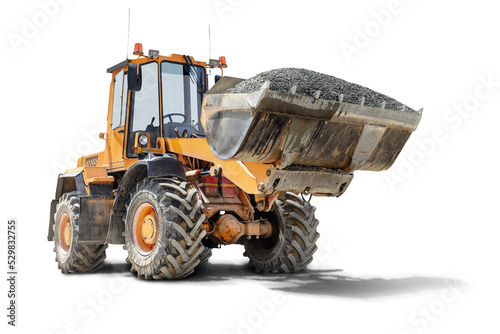 A large front loader transports crushed stone or gravel in a bucket at a construction site. Transportation of bulk materials. Isolated loader on a white background.