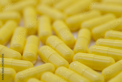 Many yellow pills distributed, medicine, cropped image
