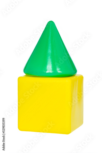 A green cone on a yellow cube from a children`s toy set stacked into a piramid. Children`s construction game. Developmental creativity