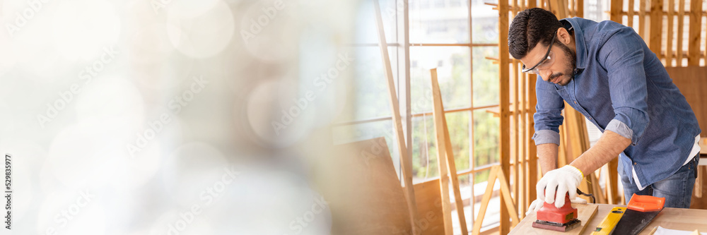 Web banner Smart and good looking Asian male carpenter I am designing furniture to decorate my house professionally with copy space on left Web banner Smart and good looking Asian male carpenter I am designing furniture to decorate my house professionally with copy space on left
