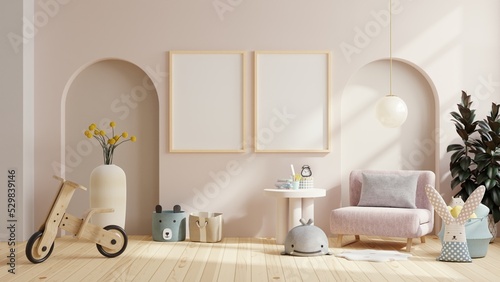 Mockup frame in the children's room with pink armchair on cream color wall.
