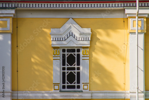 Ascension Cathedral wooden window frame on yellow wall, Russian Orthodox Cathedral in Almaty, Kazakhstan