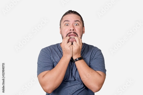 A shocked man panics, pulling on his mouth with his fingers. Scared at screwing up at his job or personal affairs. Isolated on a white background. photo