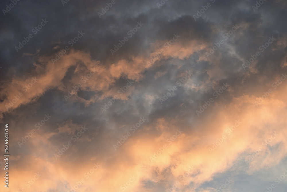 Orange in blue evening light sky before sunset. Calm atmosphere in autumn. Darken clouds in natural sky with colorful pastel tone colors for background. 