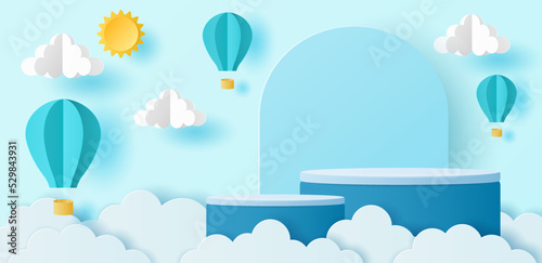 Paper cut of cylinder podium with hot air balloons, sun and clouds on blue sky background  for your products display presentation.