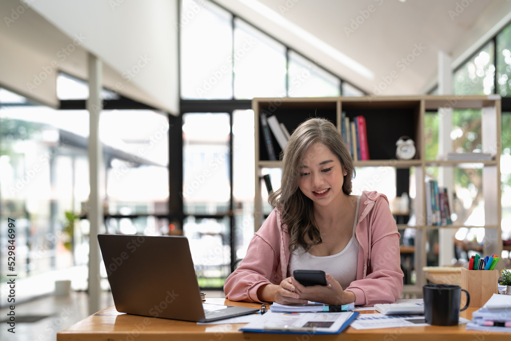 Attractive asian woman using mobile phone during checking an email or social media on internet. accounting financial concept. Attractive asian woman using mobile phone during checking an email or social media on internet. accounting financial concept.