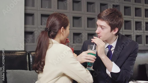 Couple woman and man drinking, crossing arm. Businessman and businesswoman love and look together at hotel. 