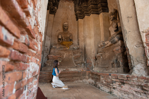 Young Asian women tourist traveling at Wat Chaiwatthanaram, ancient buddhist temple, famous and major tourist attraction religious of Phra Nakhon Si Ayutthaya, Thailand