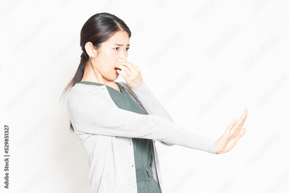悪臭に困って鼻をつまんでいる女性 悪臭に困って鼻をつまんでいる女性