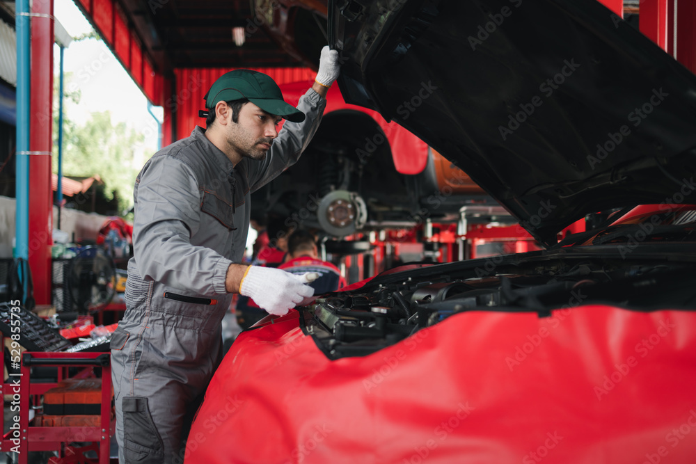 Obraz premium Automobile mechanic man checking car damage broken part condition. diagnostic and repairing vehicle at garage automotive, Concepts of car care check and fixed and services insurance.