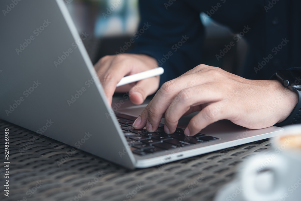 Business man working on laptop computer, hand typing keyboard. Casual business man, freelancer online working at coffee shop, surfing the internet Business man working on laptop computer, hand typing keyboard. Casual business man, freelancer online working at coffee shop, surfing the internet