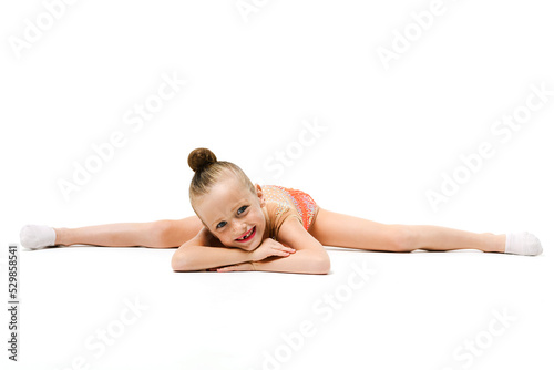 Small female gymnast lay in split down © o_lypa