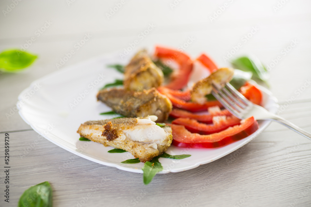 Pieces of fried hake fish in a plate with pepper Pieces of fried hake fish in a plate with pepper